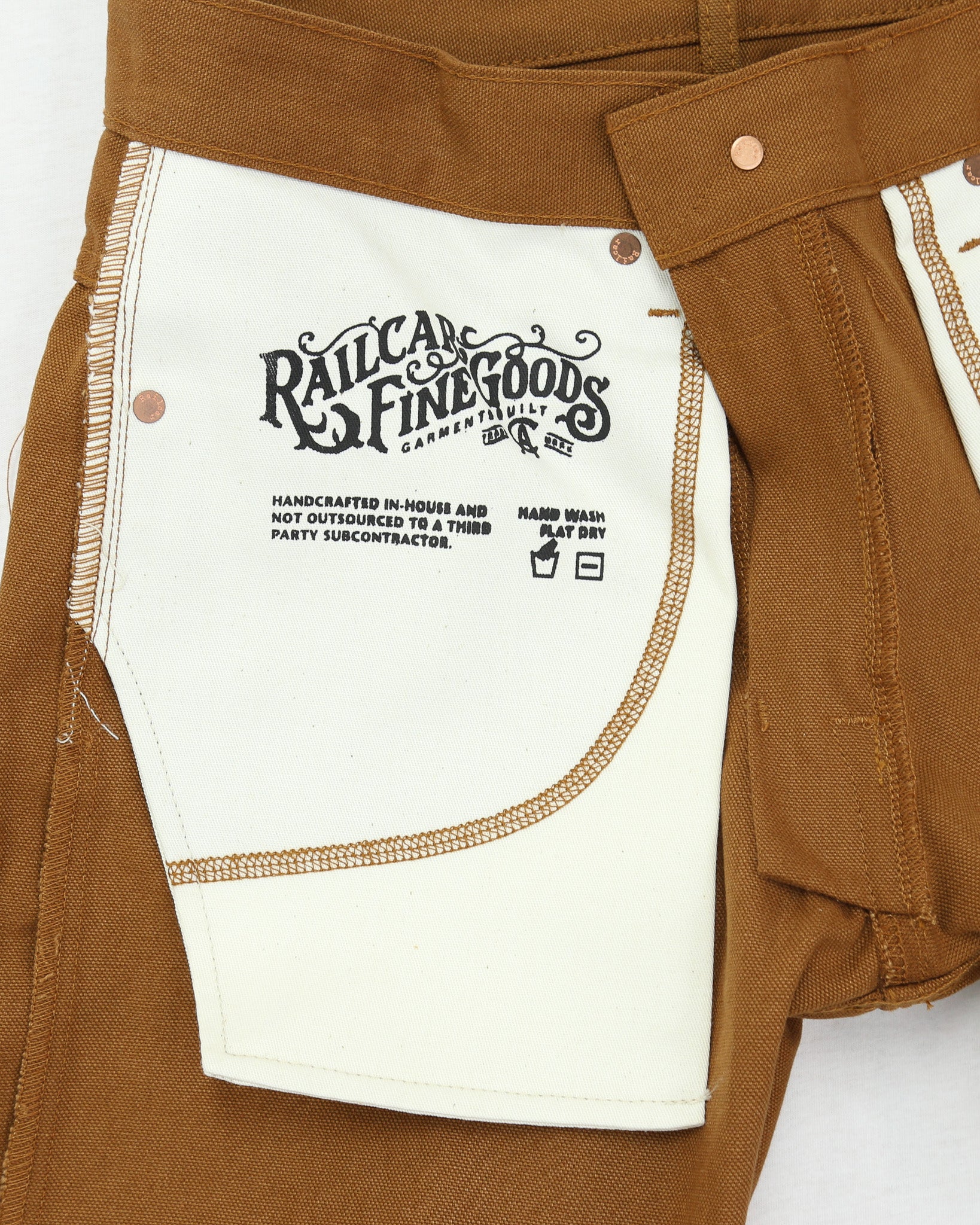 Brown work pants with a visible brand label on a white background