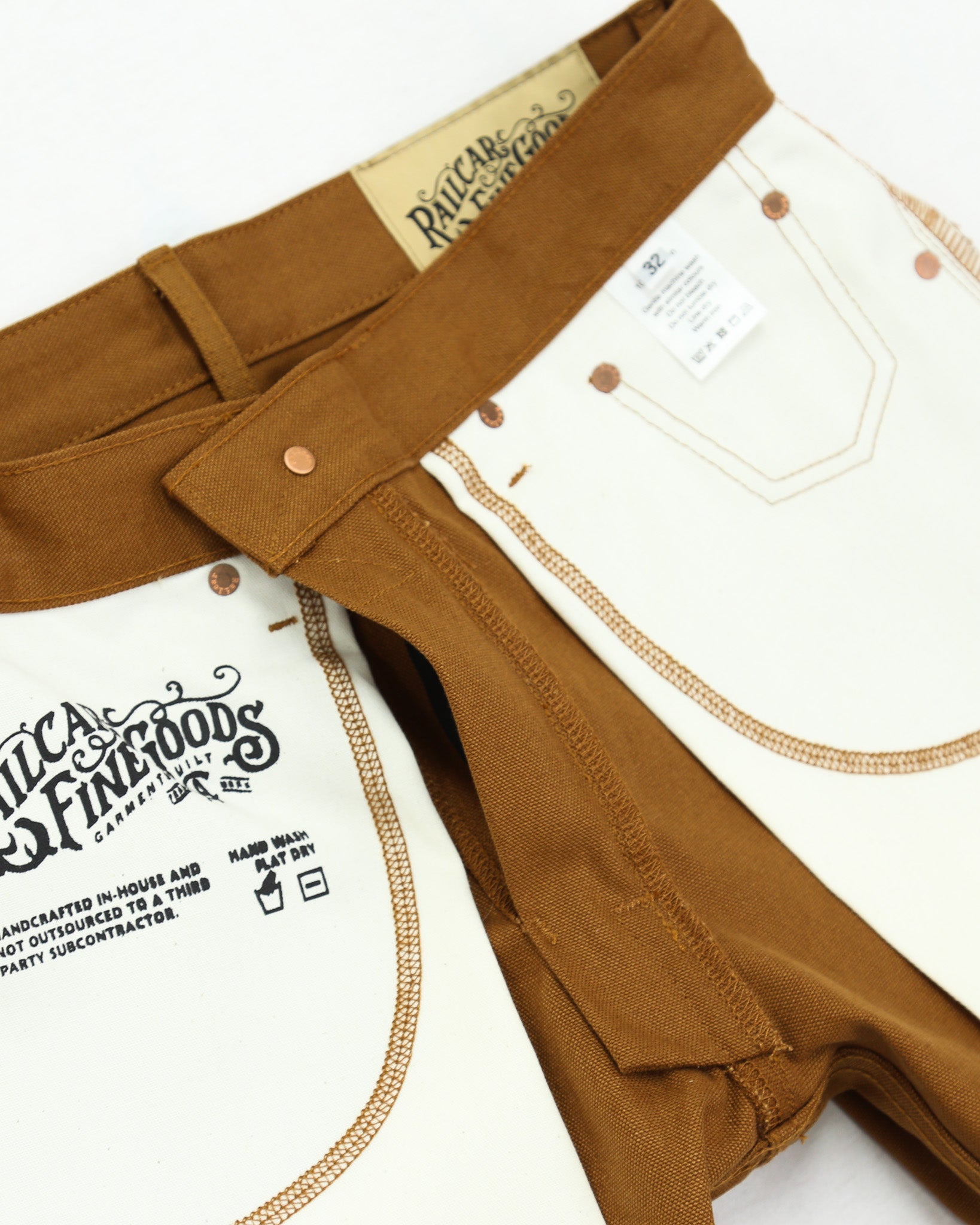 Brown canvas pants with visible branding on a white background