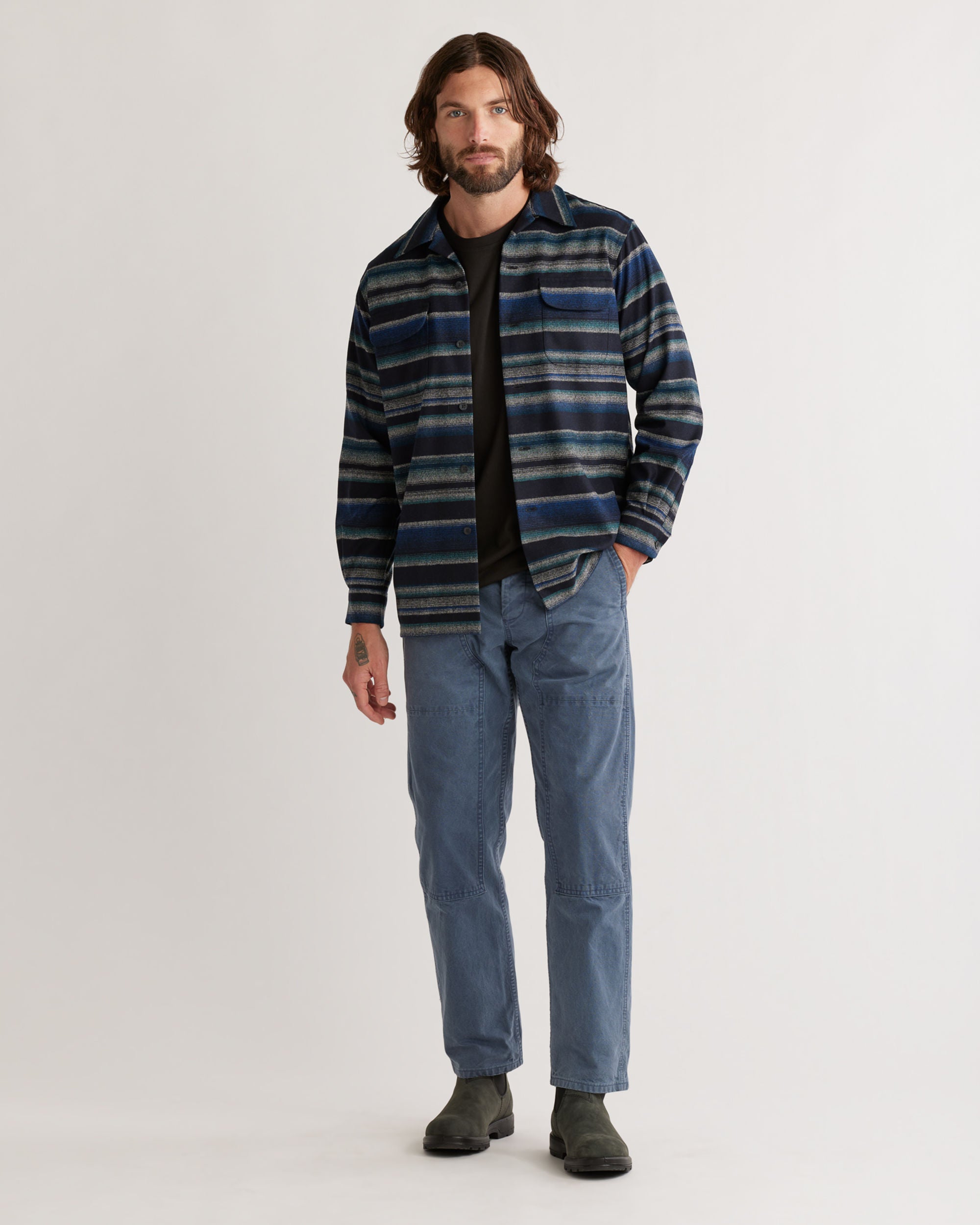 Man wearing a striped shirt and jeans on a white background