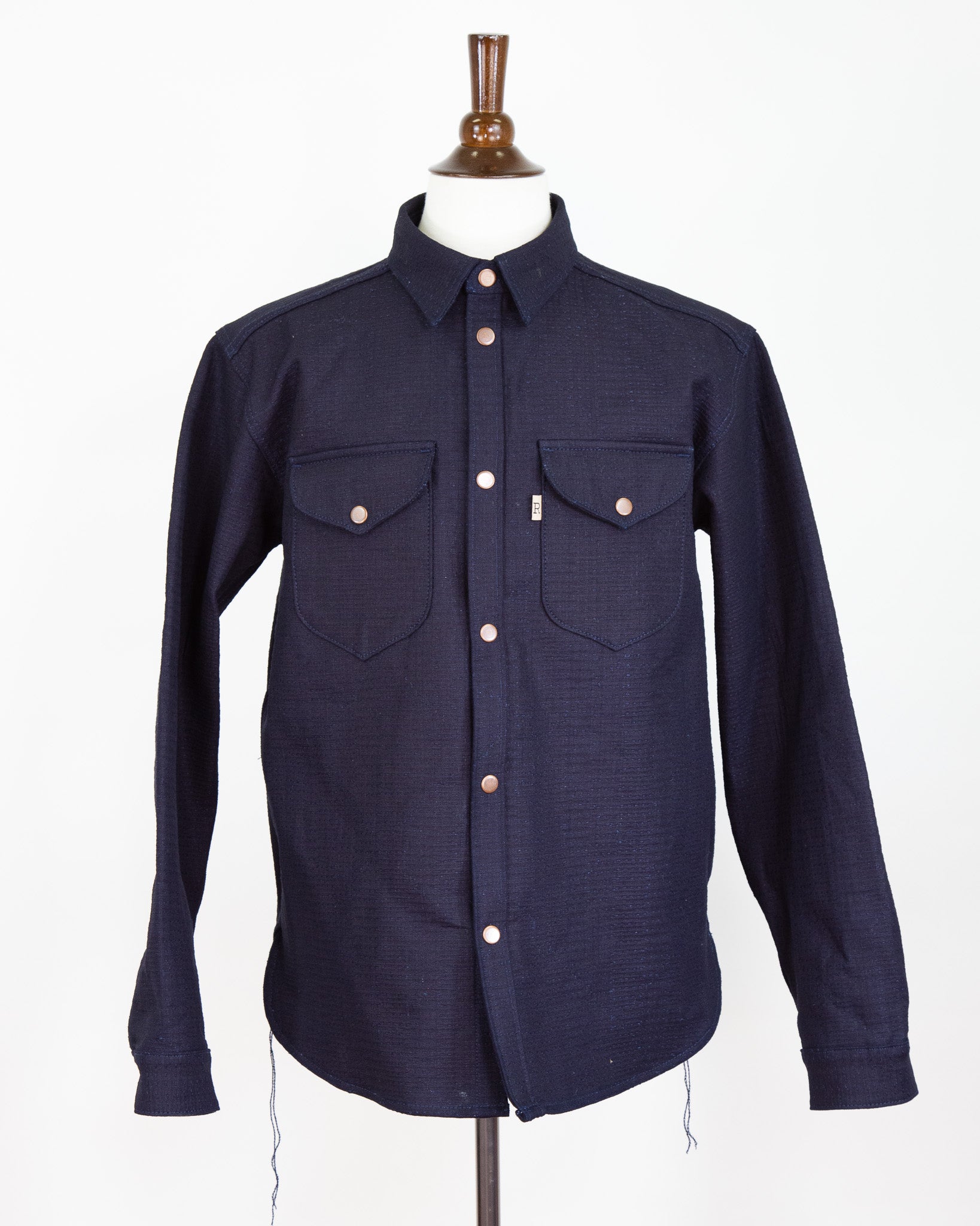 Navy blue shirt on a mannequin with a white background