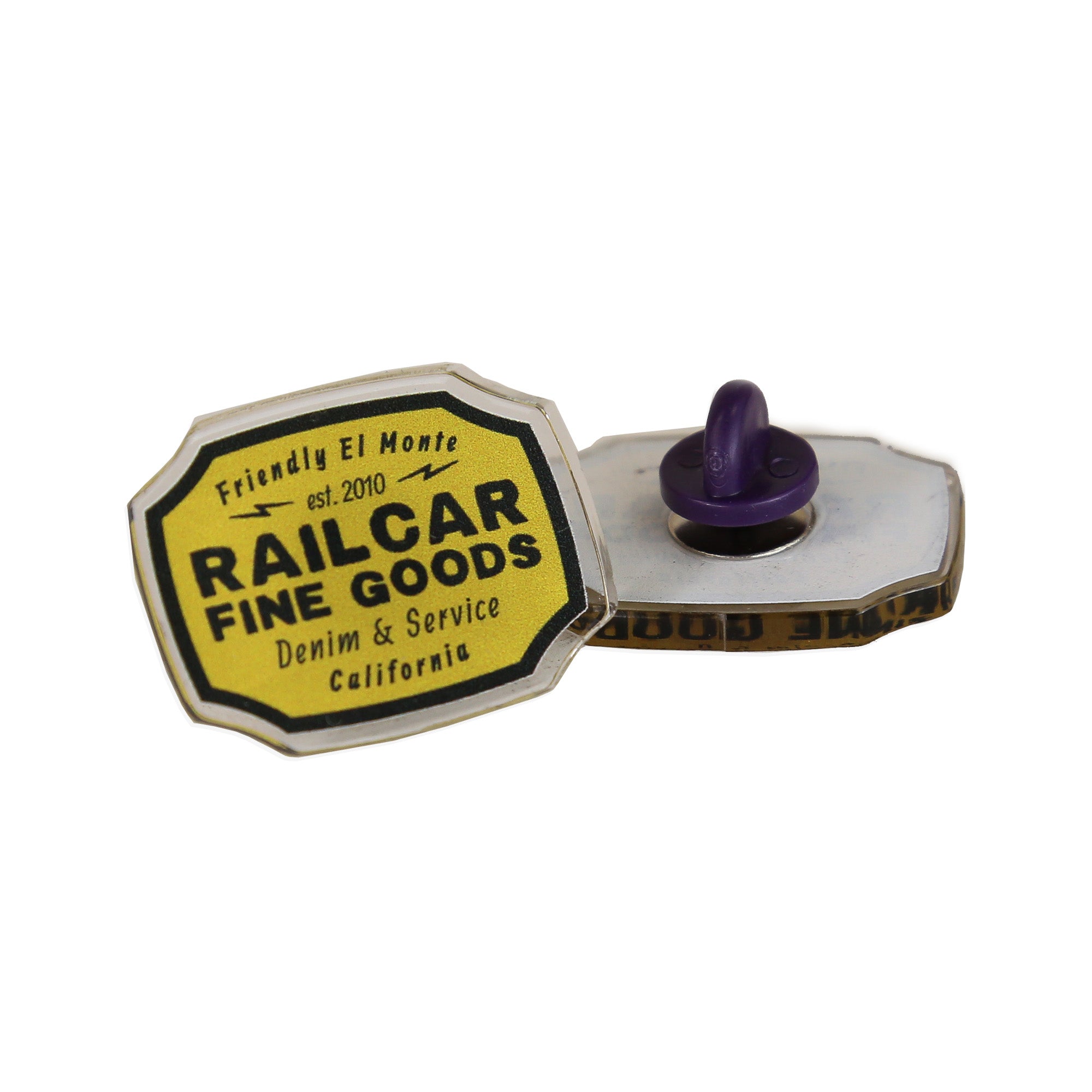 An acrylic pin with a yellow and black Railcar brand label