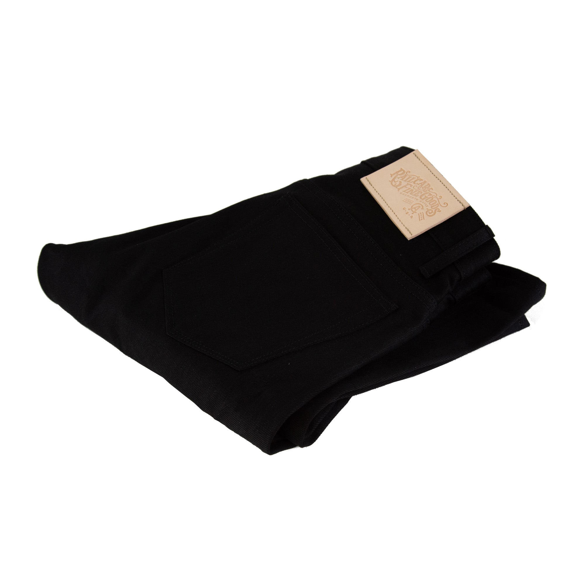 Folded Pair of Spikes X111 Taper Leg 13.5 Oz Double Black Selvedge showing leather detail