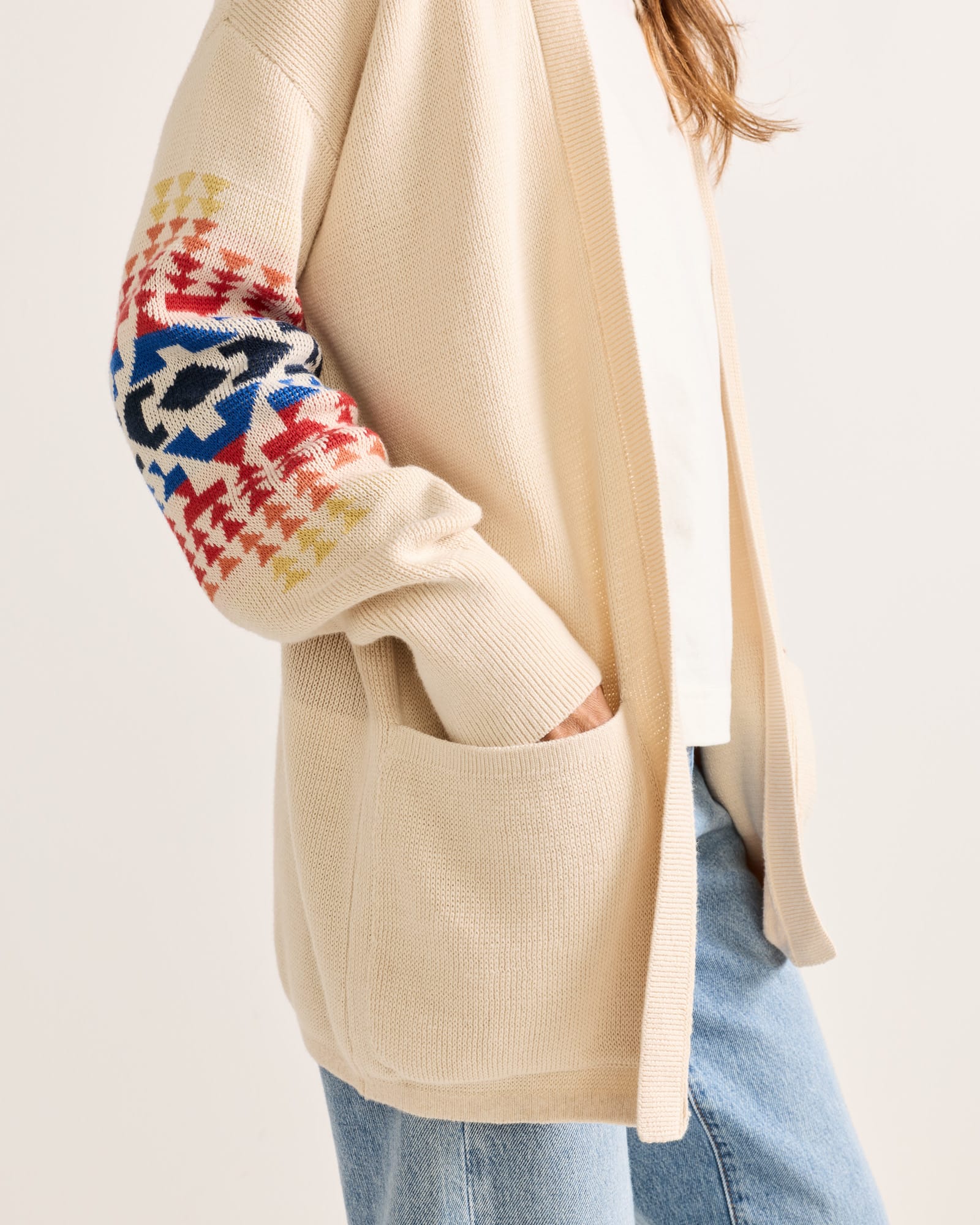 Beige cardigan with colorful sleeve pattern on a white background