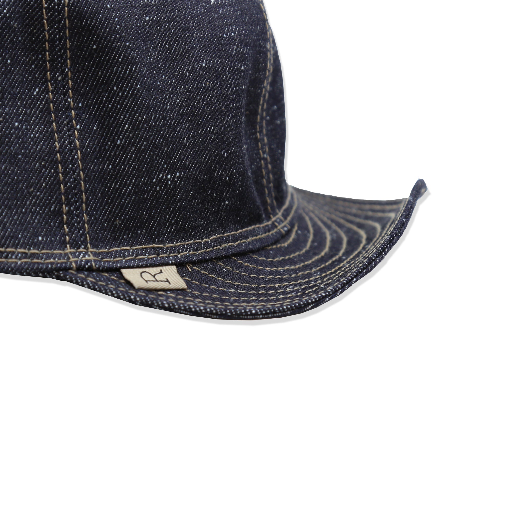Bill detail of A dark blue nep denim mechanic hat with visible stitching.